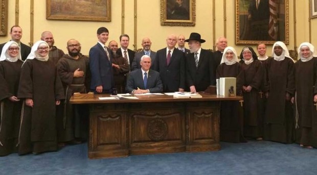 O governador Mike Pence, rodeado por religiosos, ao assinar polêmica lei na quinta-feira. (Foto: Divulgação)